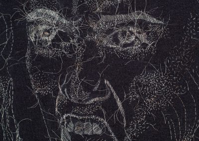Black and gray face drawn/sewn from human hair shown in detail.